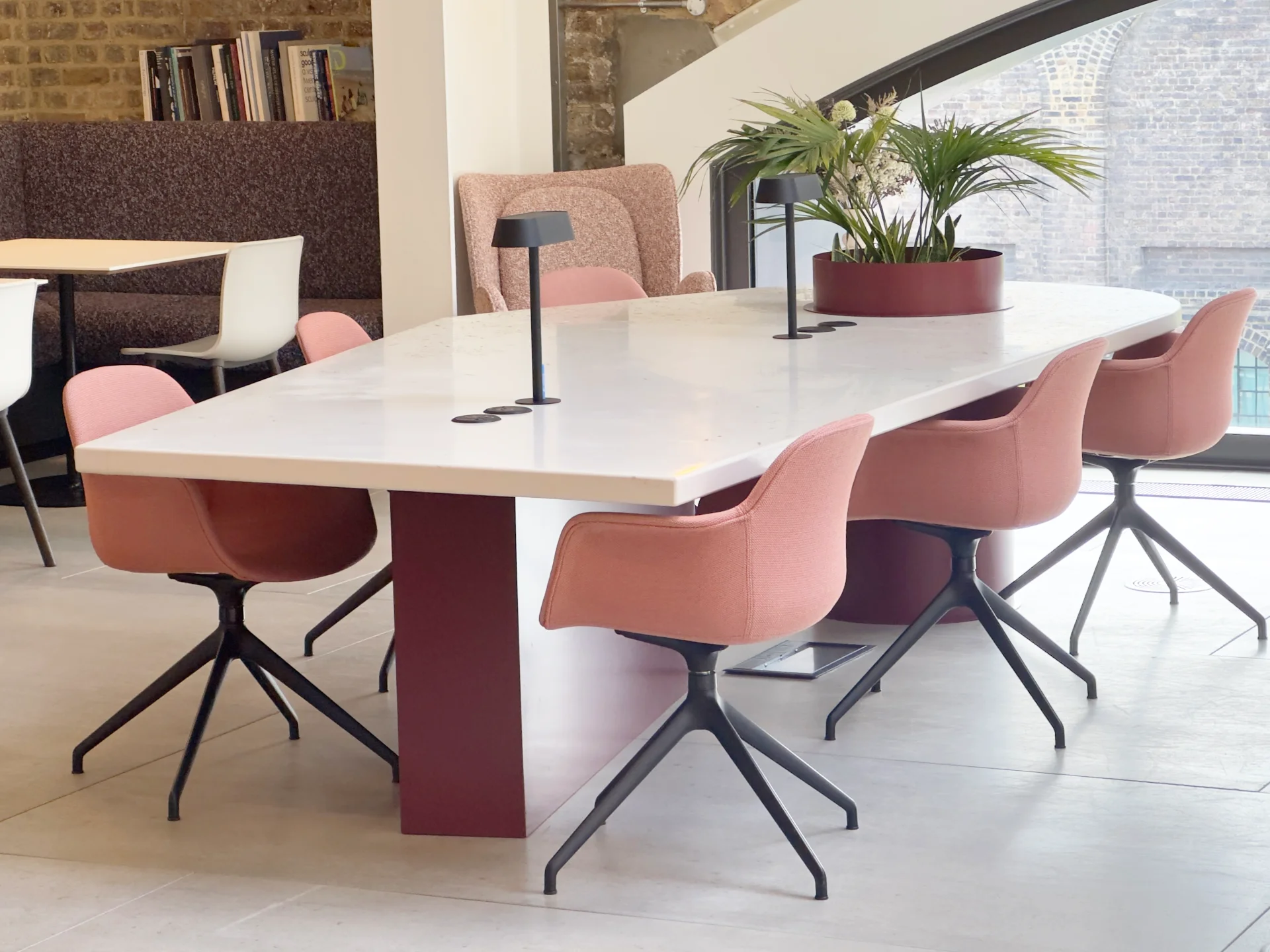 Custom breakout table with cable management, large central planter, and reclaimed flooring top